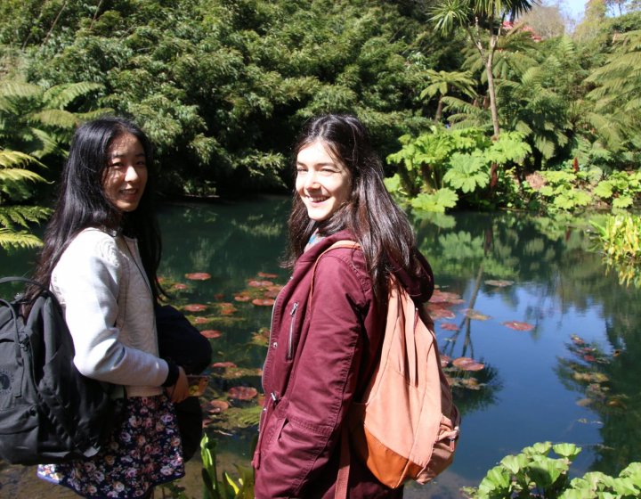Falmouth international students standing next to pond.