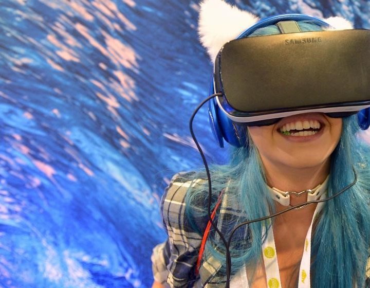 Girl wearing a VR headset in front of blue background