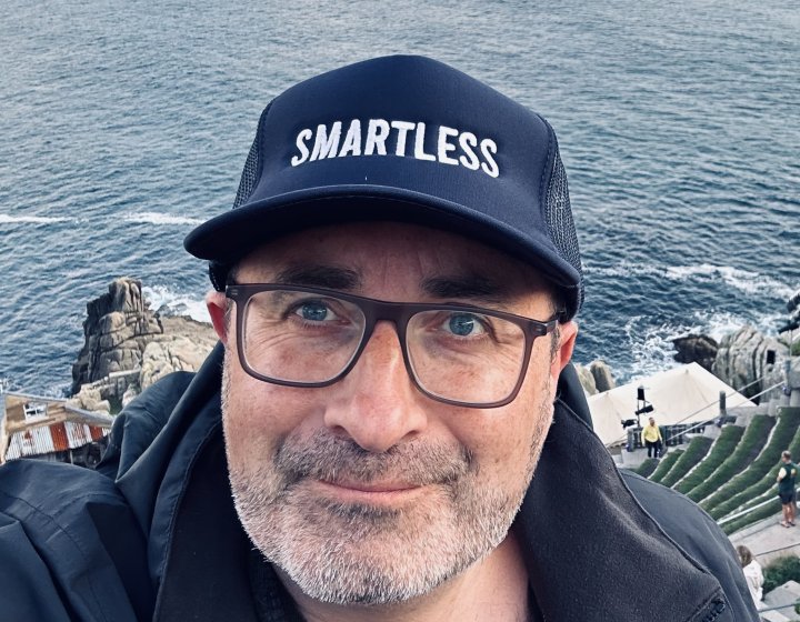 Headshot of comedy writing course leader wearing a cap