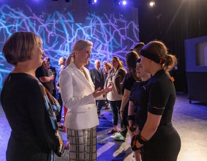 The Duchess of Edinburgh talking to two Games Academy students in a studio