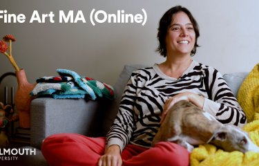 Fine Art online student Karina sat on a sofa with a dog in her lap