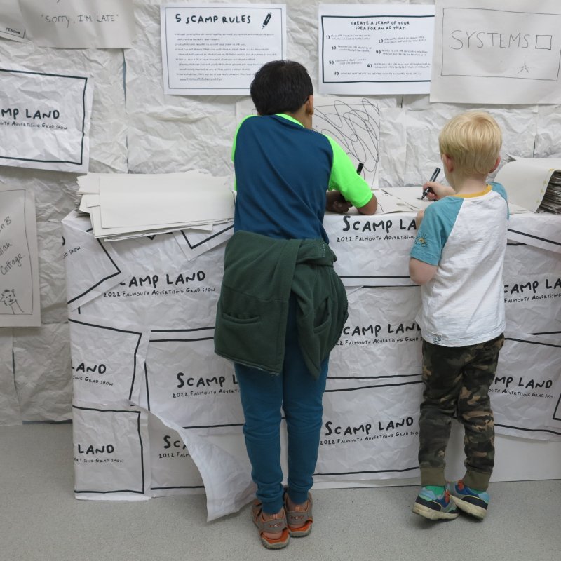 Two young children drawing during Falmouth University Community Day 2022