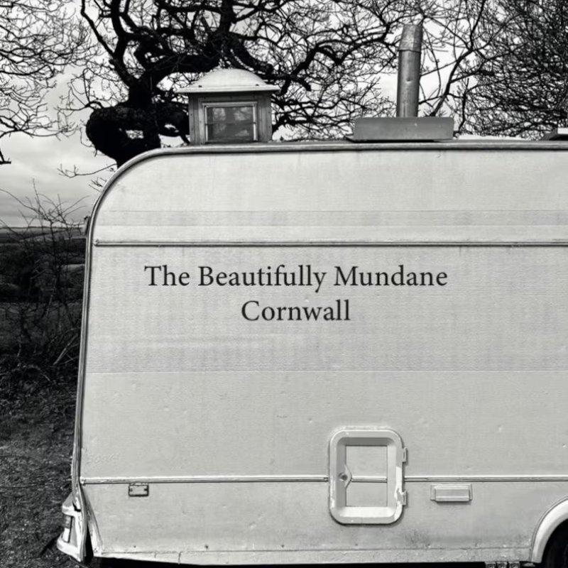 Book cover - black and white photo of an old touring caravan with the title 'The Beautifully Mundane Cornwall' in black in centre