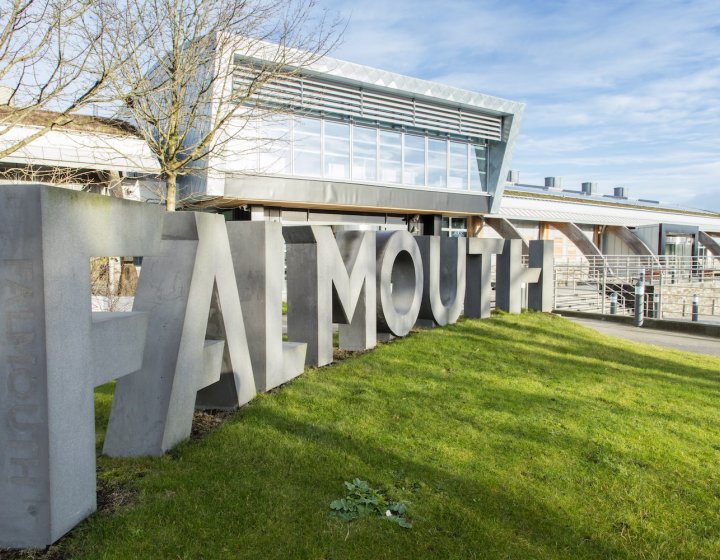Falmouth University concrete sign in front of glass building