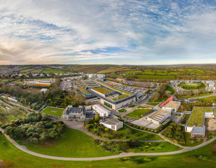 A wide angle aerial shot of Penryn campus with buildings and fields.